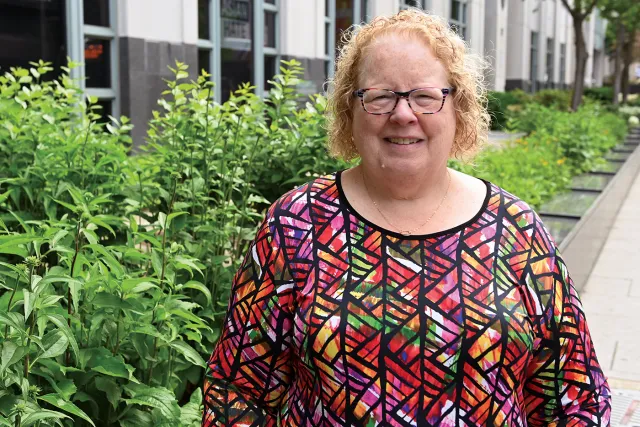 Meg Gruber stands near flowers outside the NEA building in Washington DC